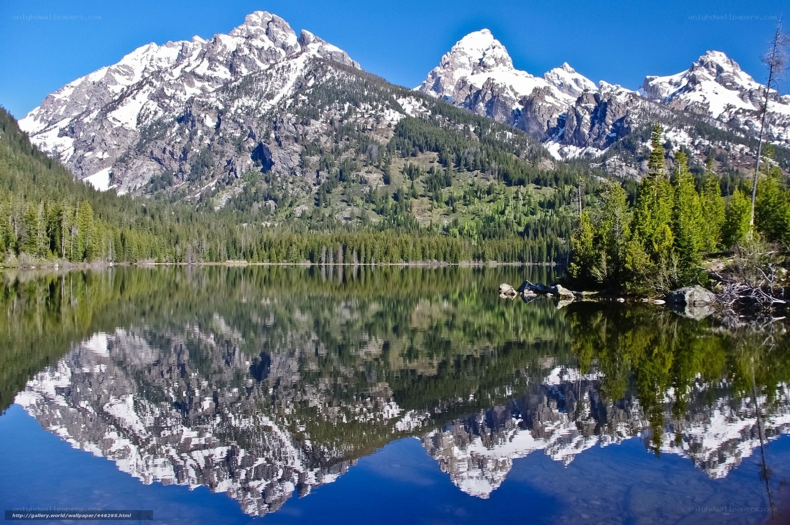 Snow-capped mountains reflect in lake