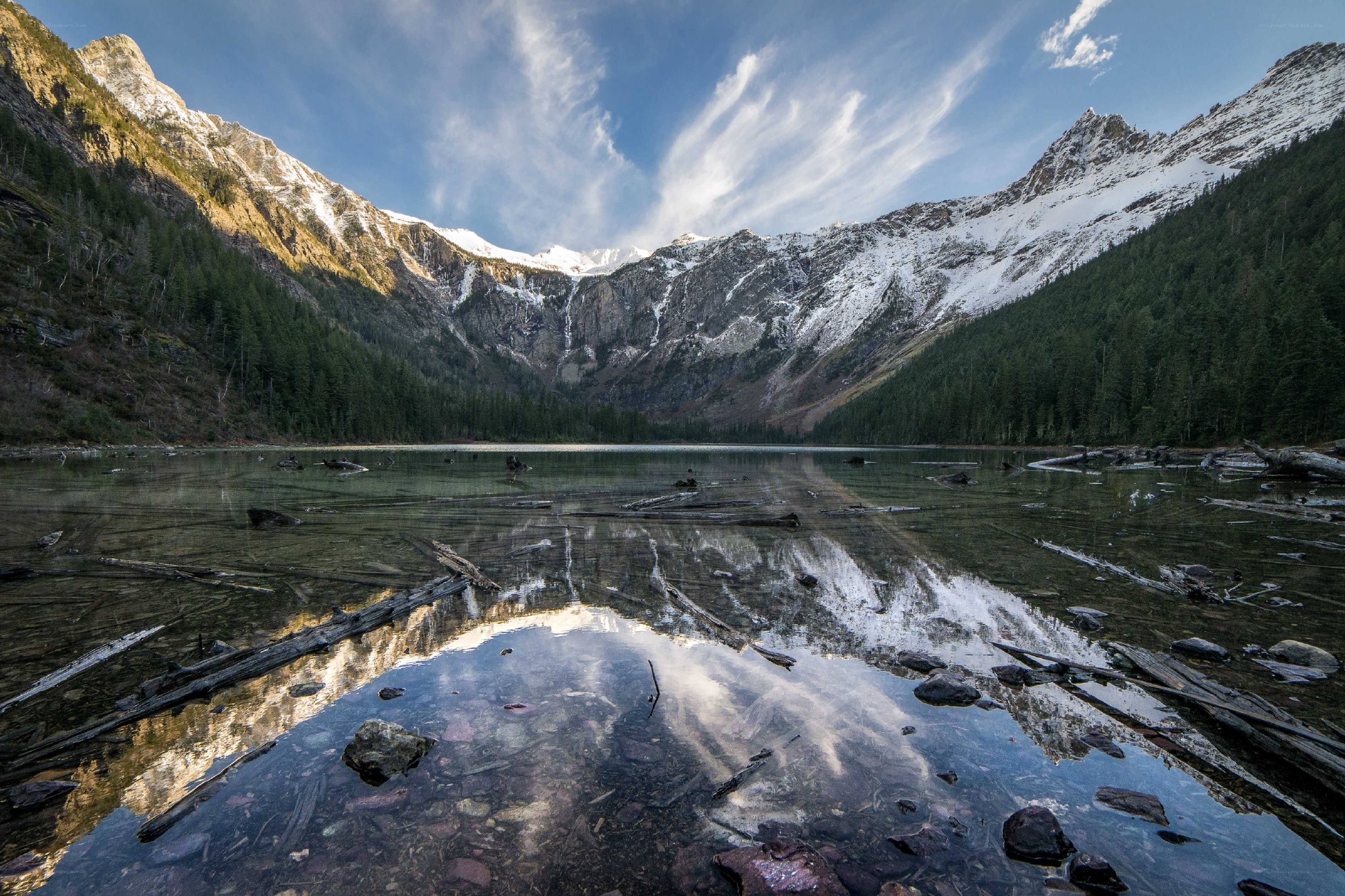 Snow-capped mountains reflect in lake