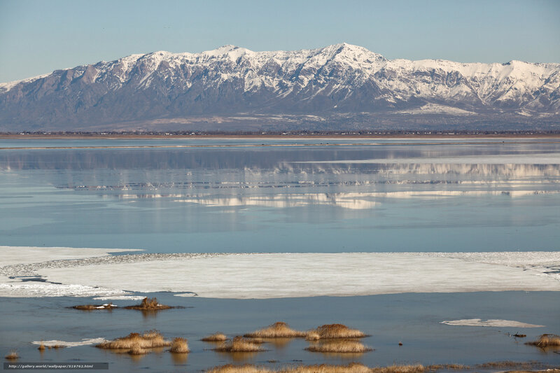 Snow-capped mountains reflect in lake