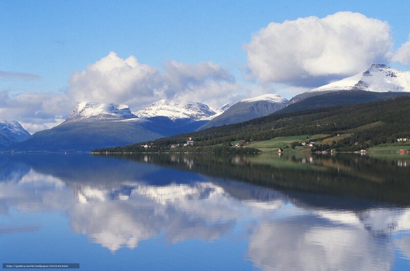 Snow-capped mountains reflect in lake