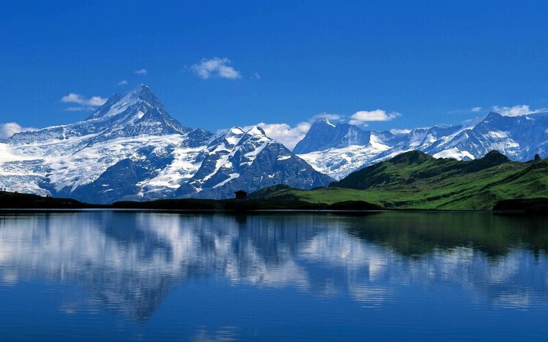 Snow-capped mountains reflect in lake