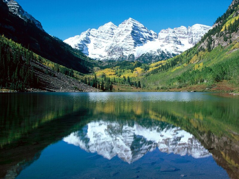 Snow-capped mountains reflect in lake