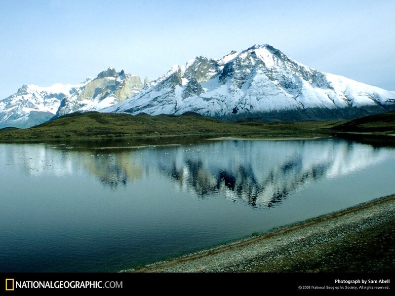 Snow-capped mountains reflect in lake
