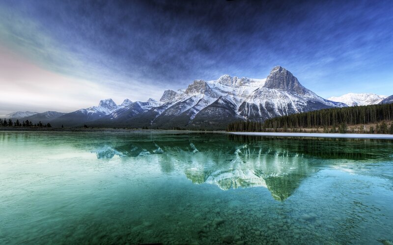 Snow-capped mountains reflect in lake