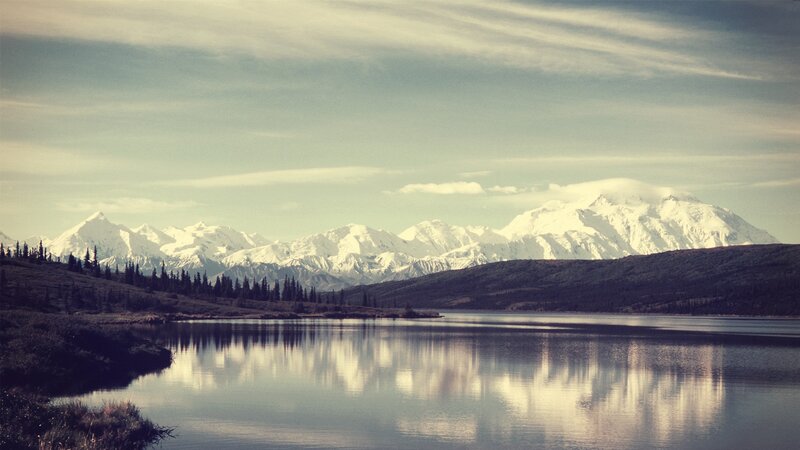 snow-capped mountains reflect in lake