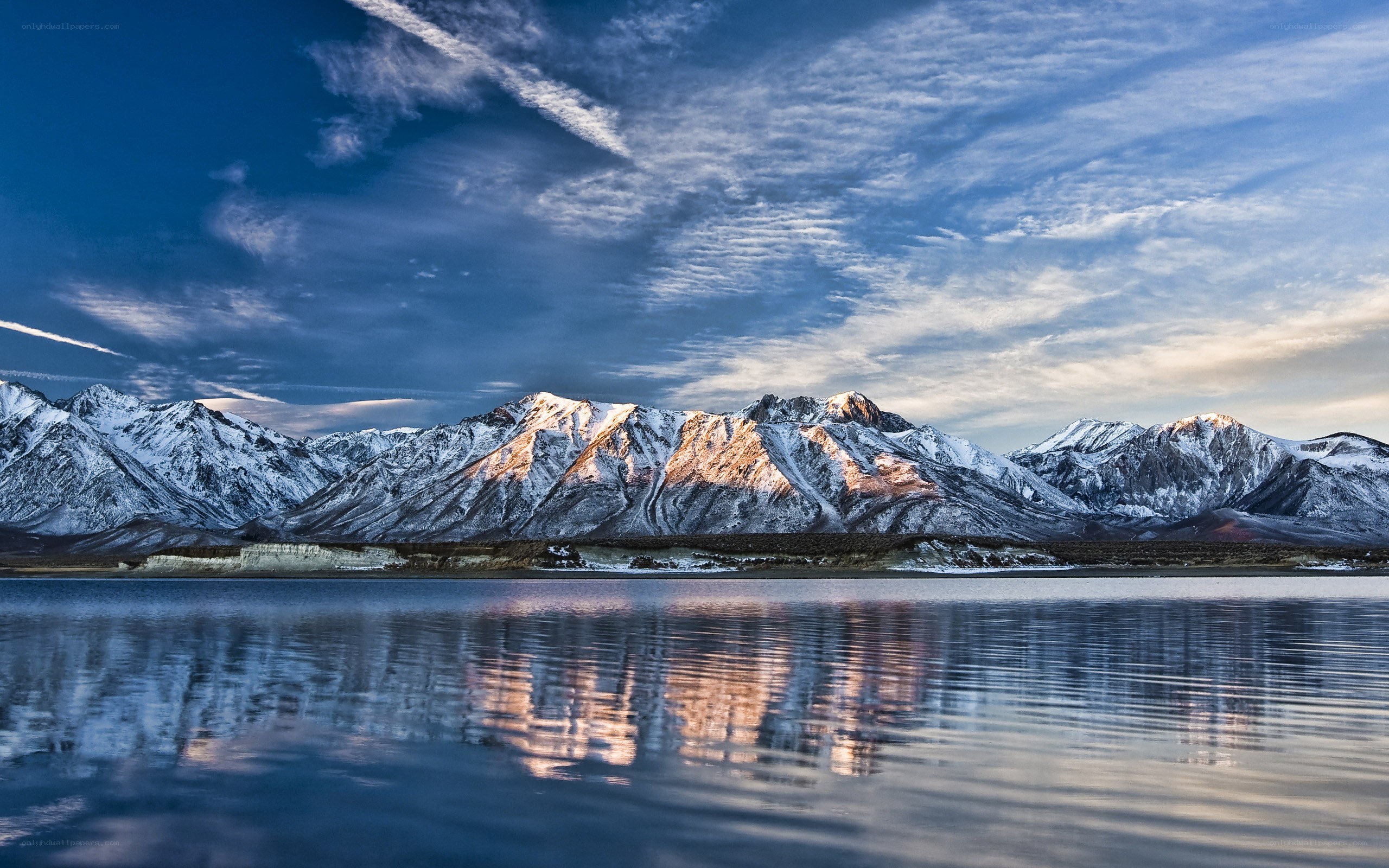 Snow-capped mountains reflect in lake