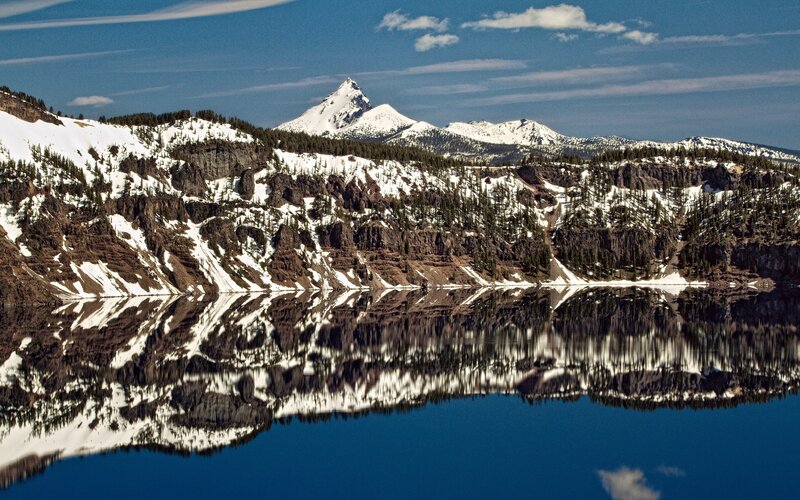 Snow-capped mountains reflect in lake