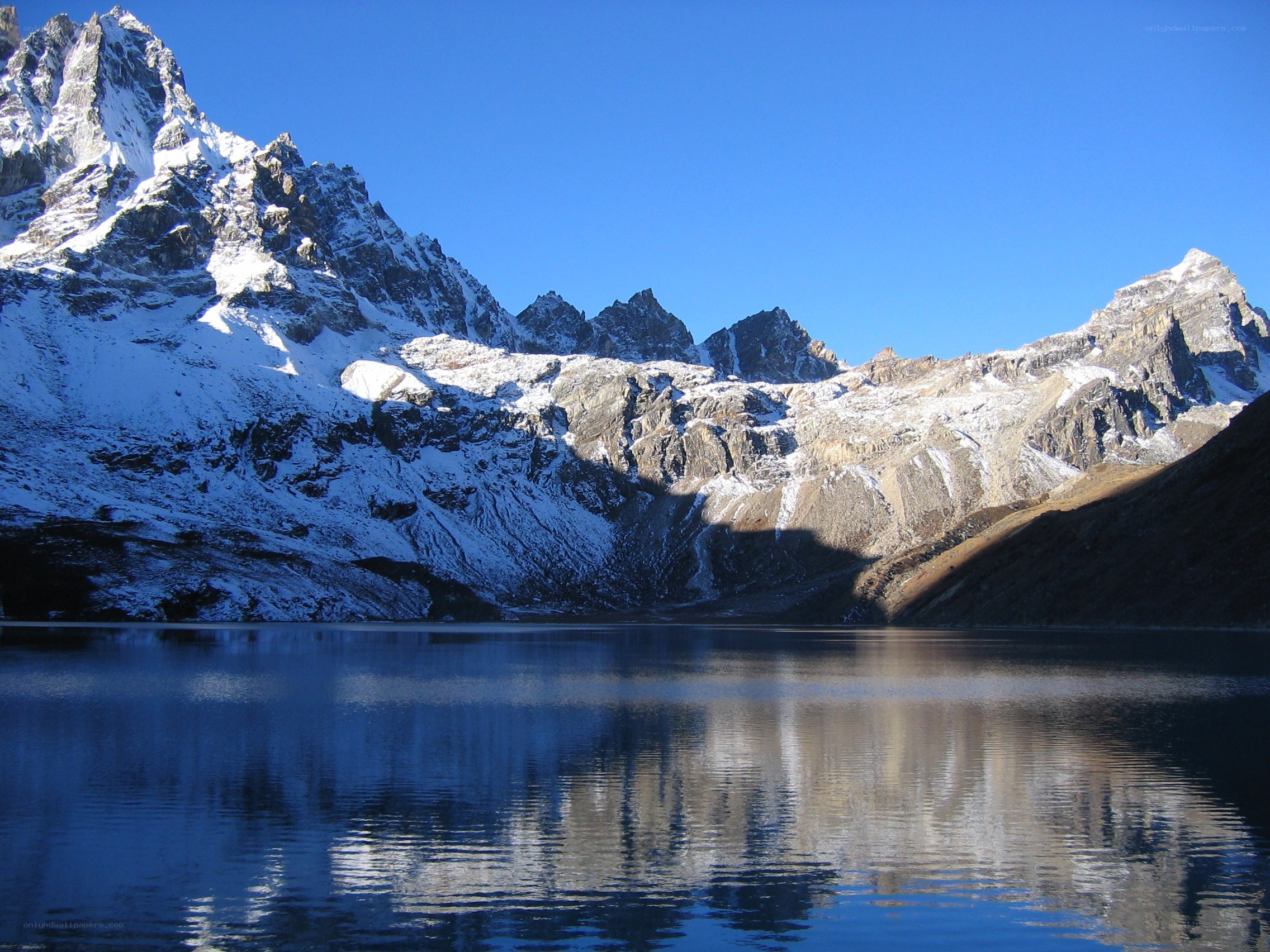 Snow-capped mountains reflect in lake