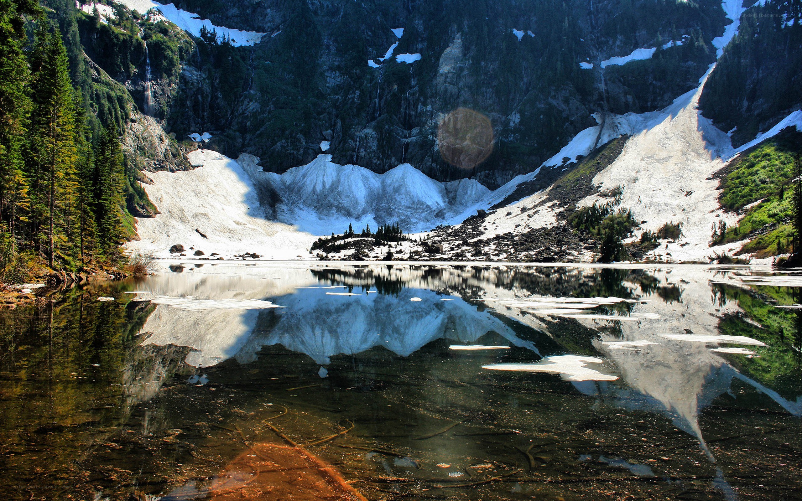 Snow-capped mountains reflect in lake
