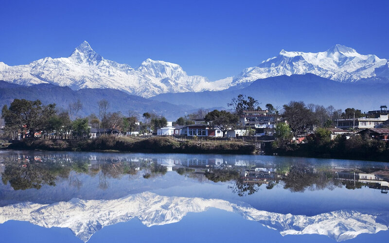 Snow-capped mountains reflect in lake