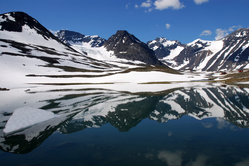 Snow-capped mountains reflect in lake