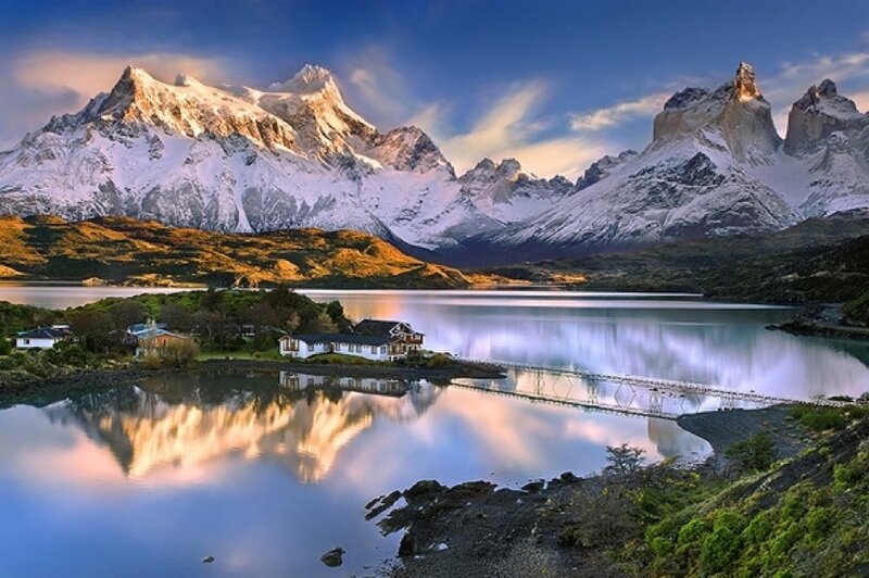 Snow-capped mountains reflect in lake