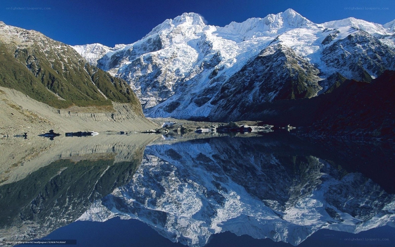 Snow-capped mountains reflect in lake