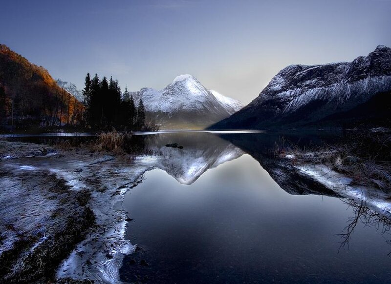 Snow-capped mountains reflect in lake