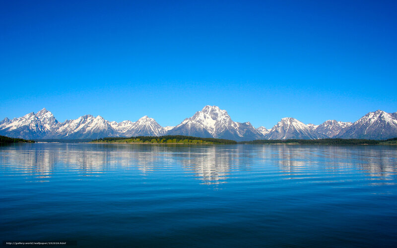 Snow-capped mountains reflect in lake