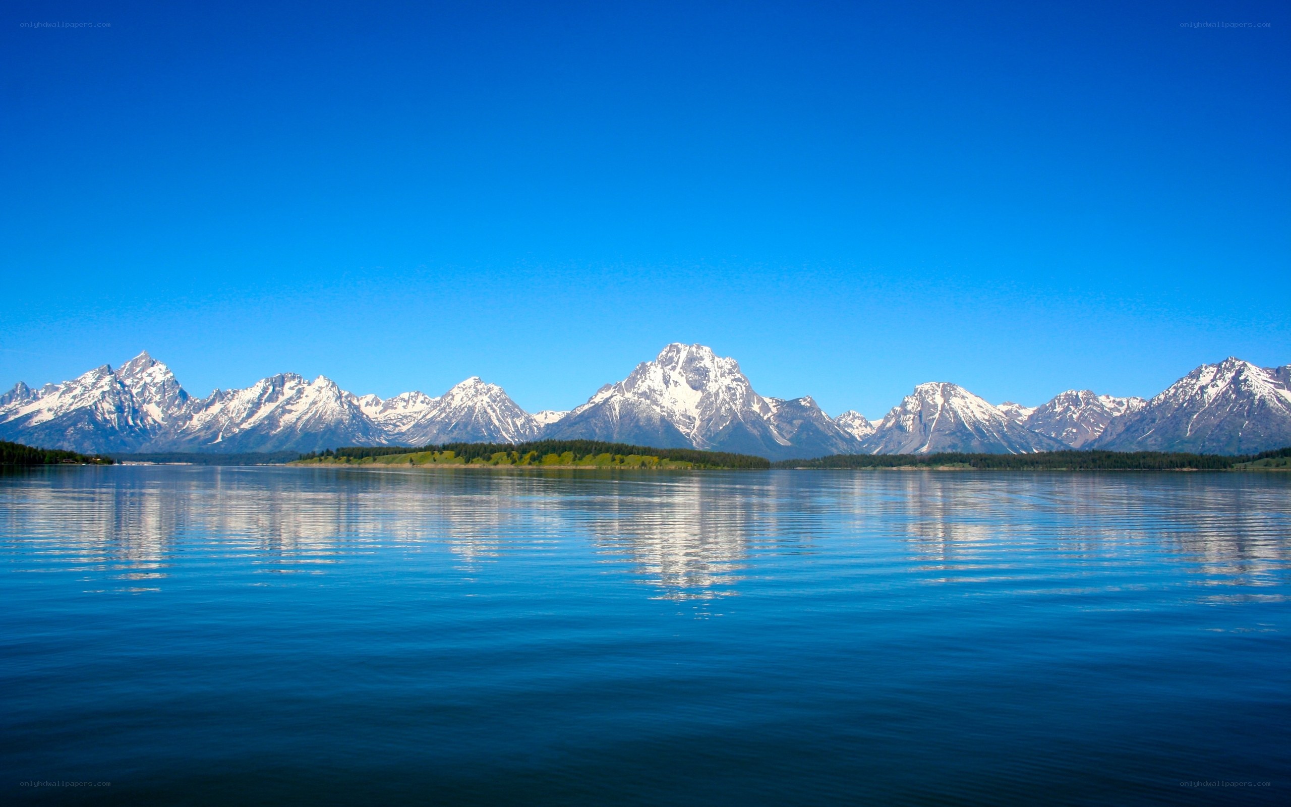 Snow-capped mountains reflect in lake