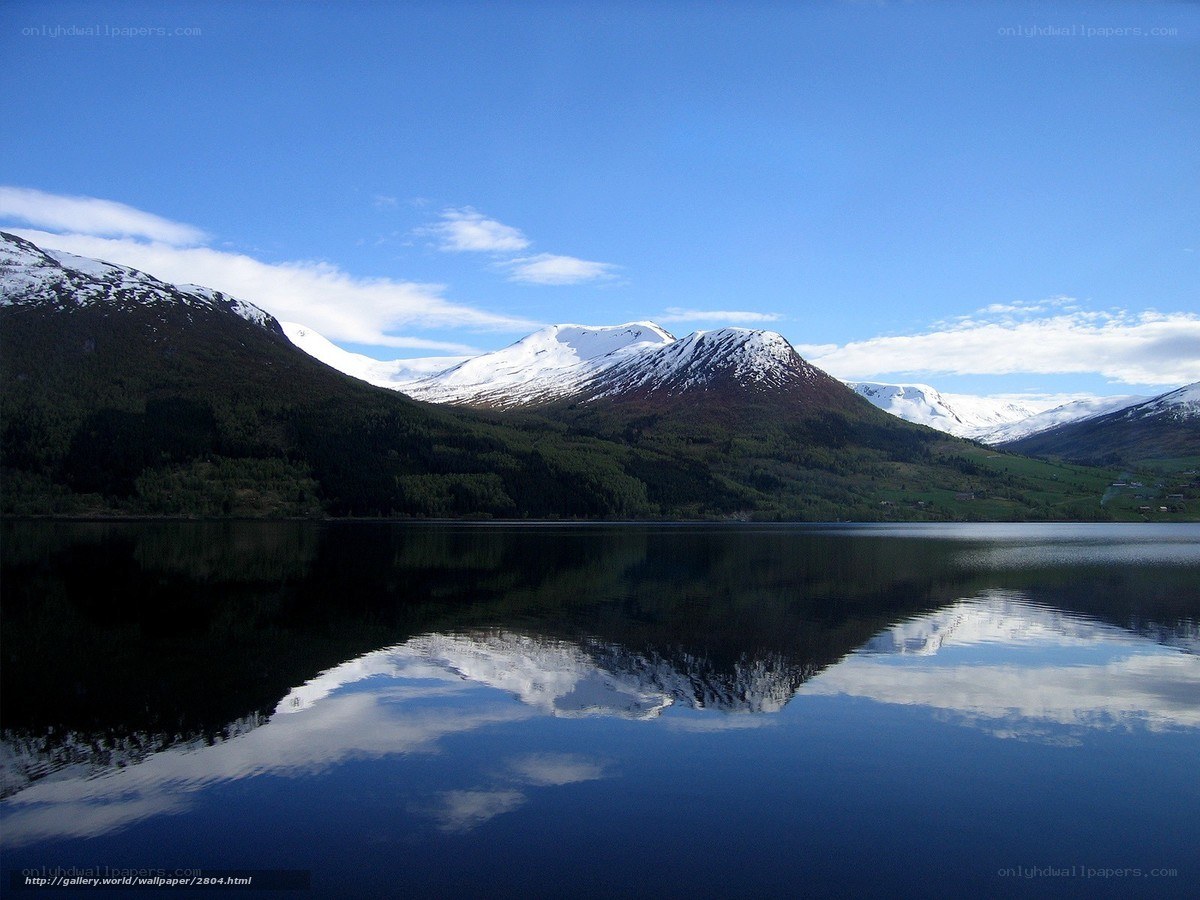 Snow-capped mountains reflect in lake