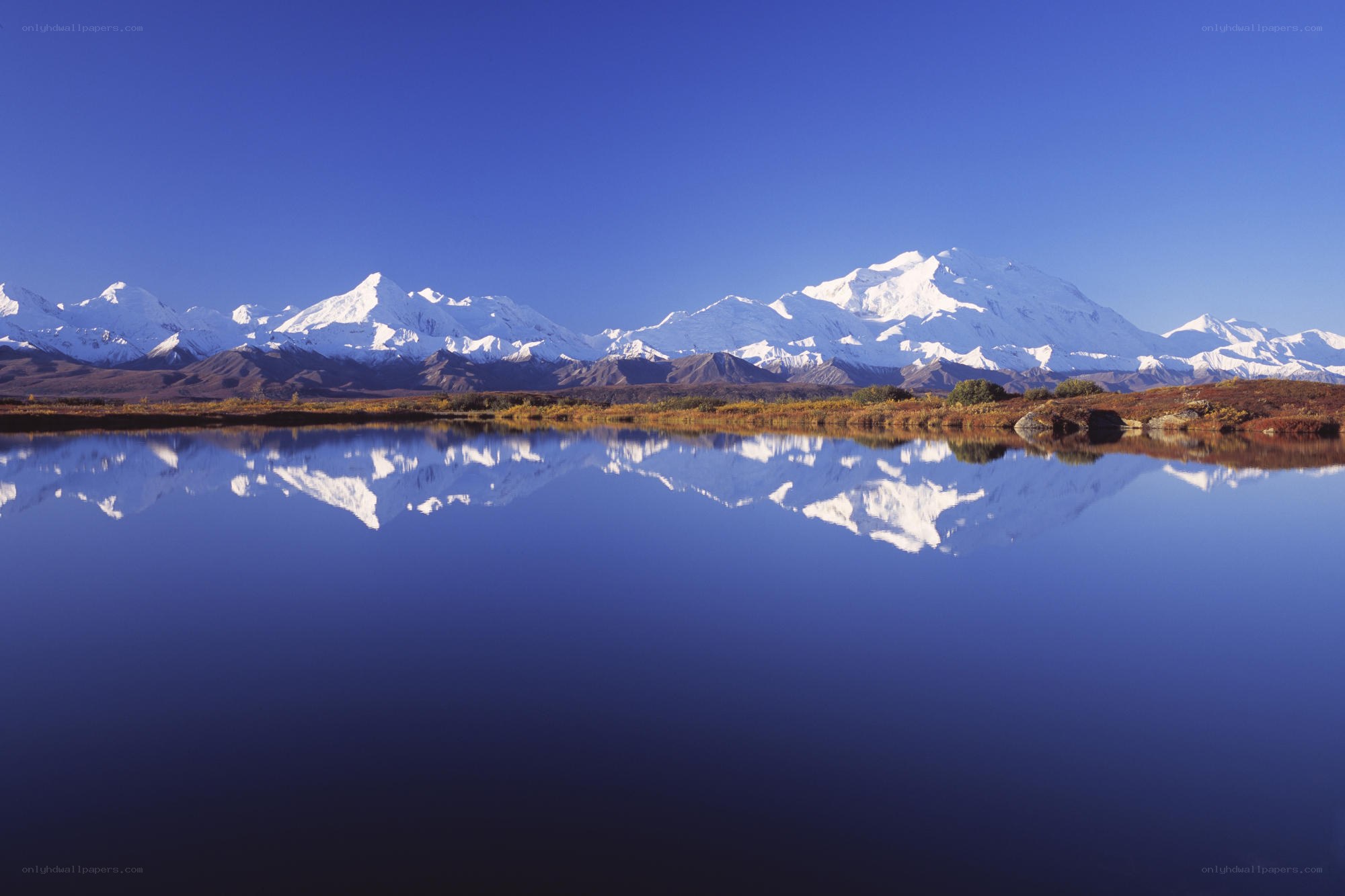 Snow-capped mountains reflected in a lake