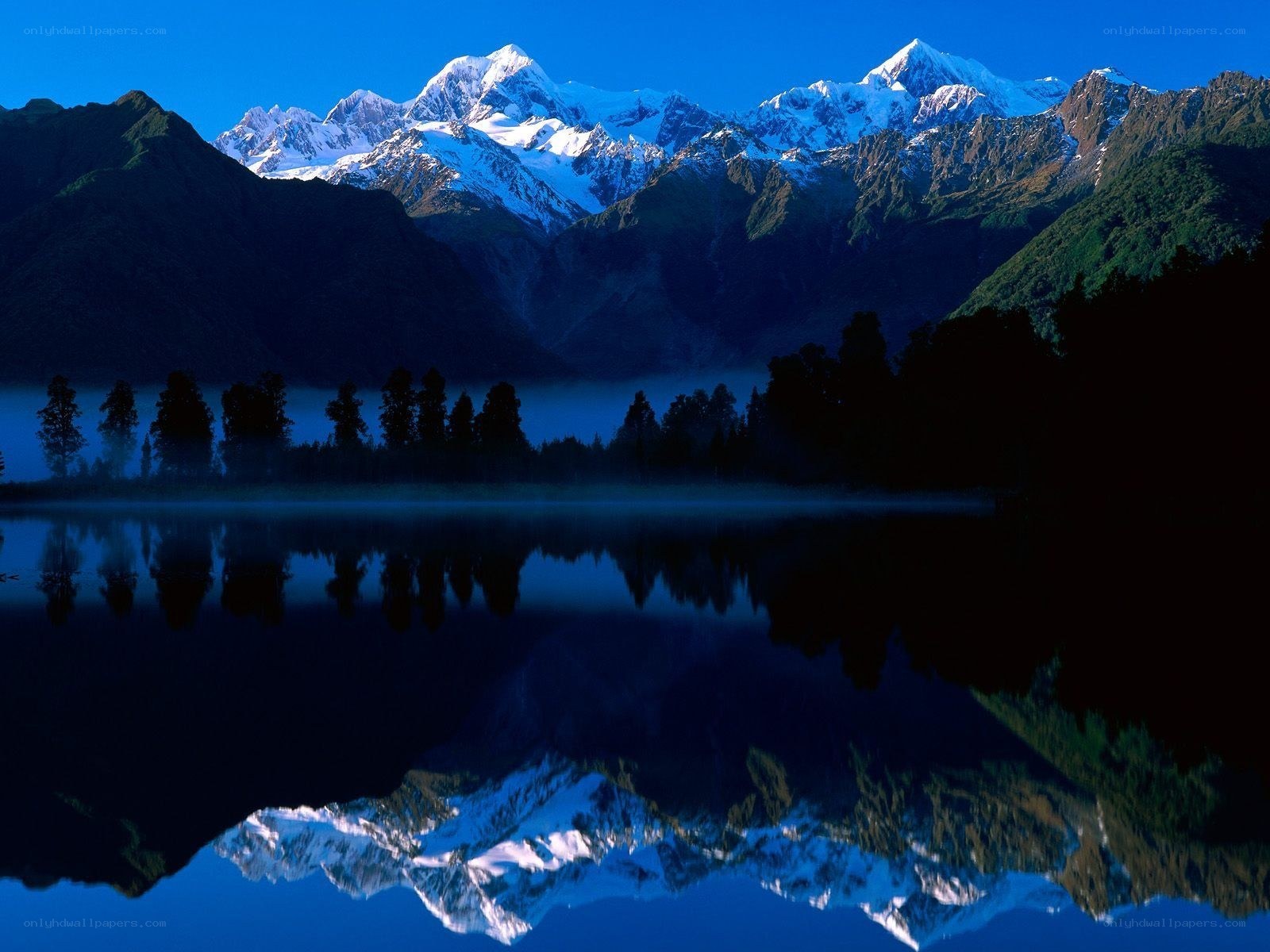 Snow-capped mountains reflected in a lake