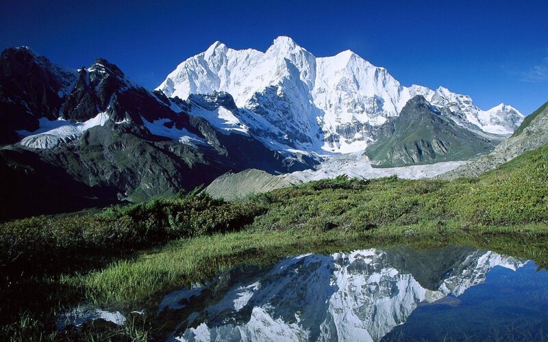 Snow-capped mountains reflected in a pond