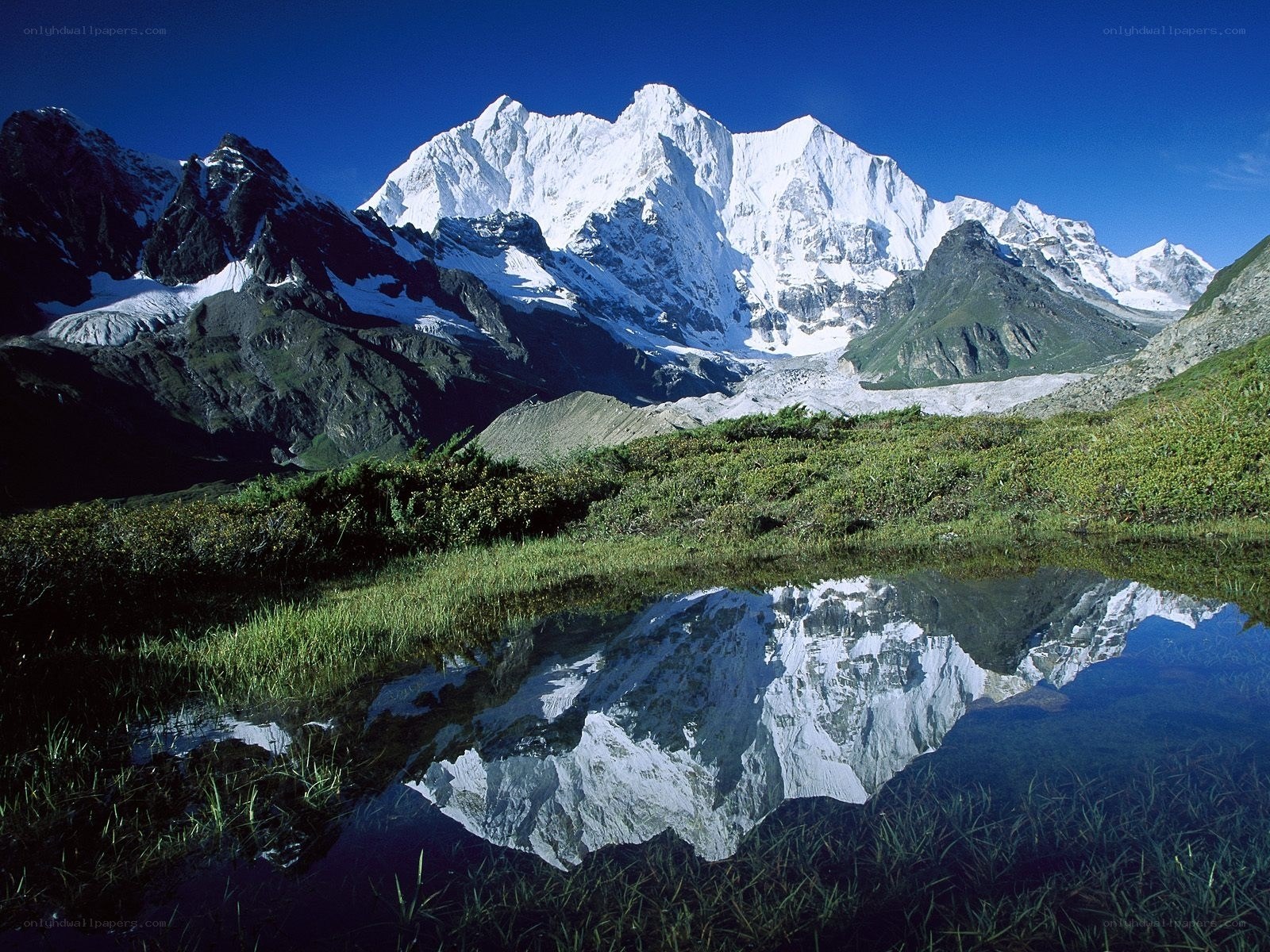 Snow-capped mountains reflected in a pond
