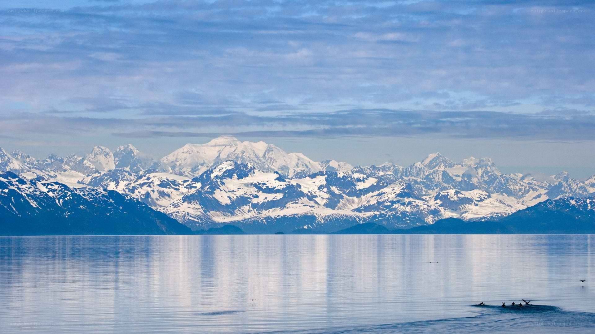 snow-capped mountains reflected in calm water