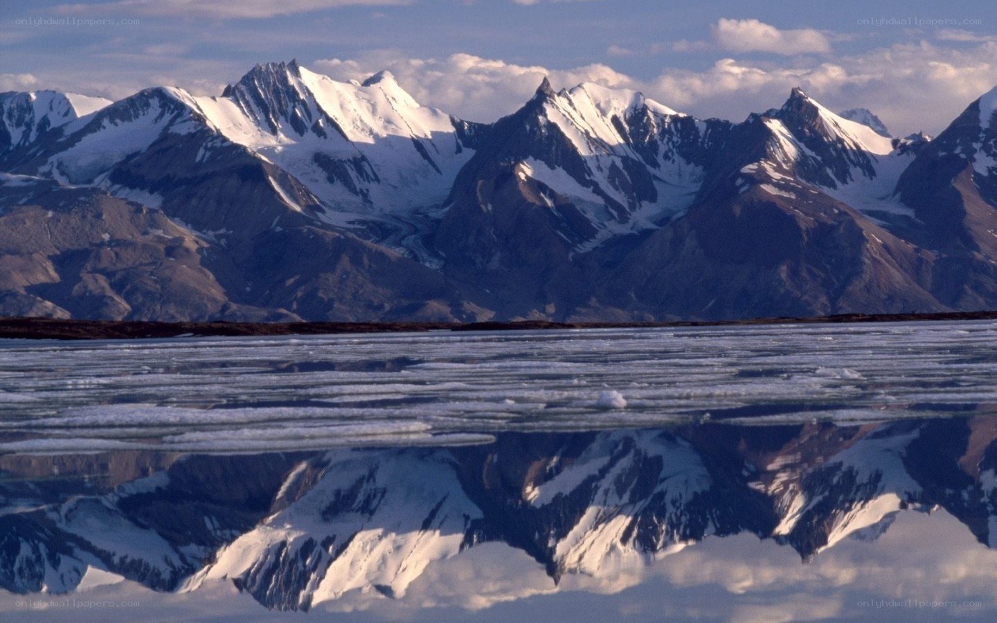 Snow-capped mountains reflected in ice