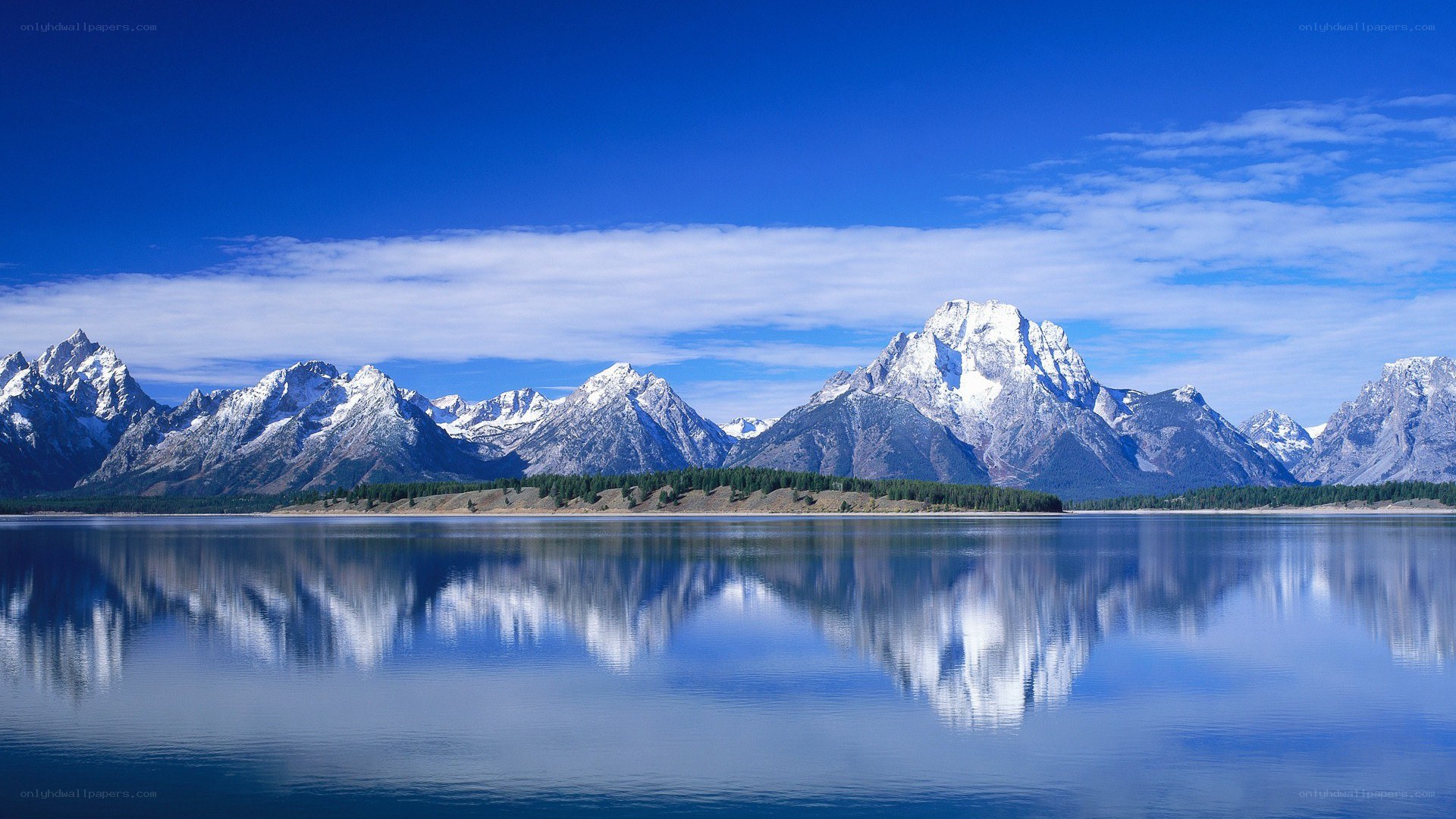 Snow-capped mountains reflected in lake