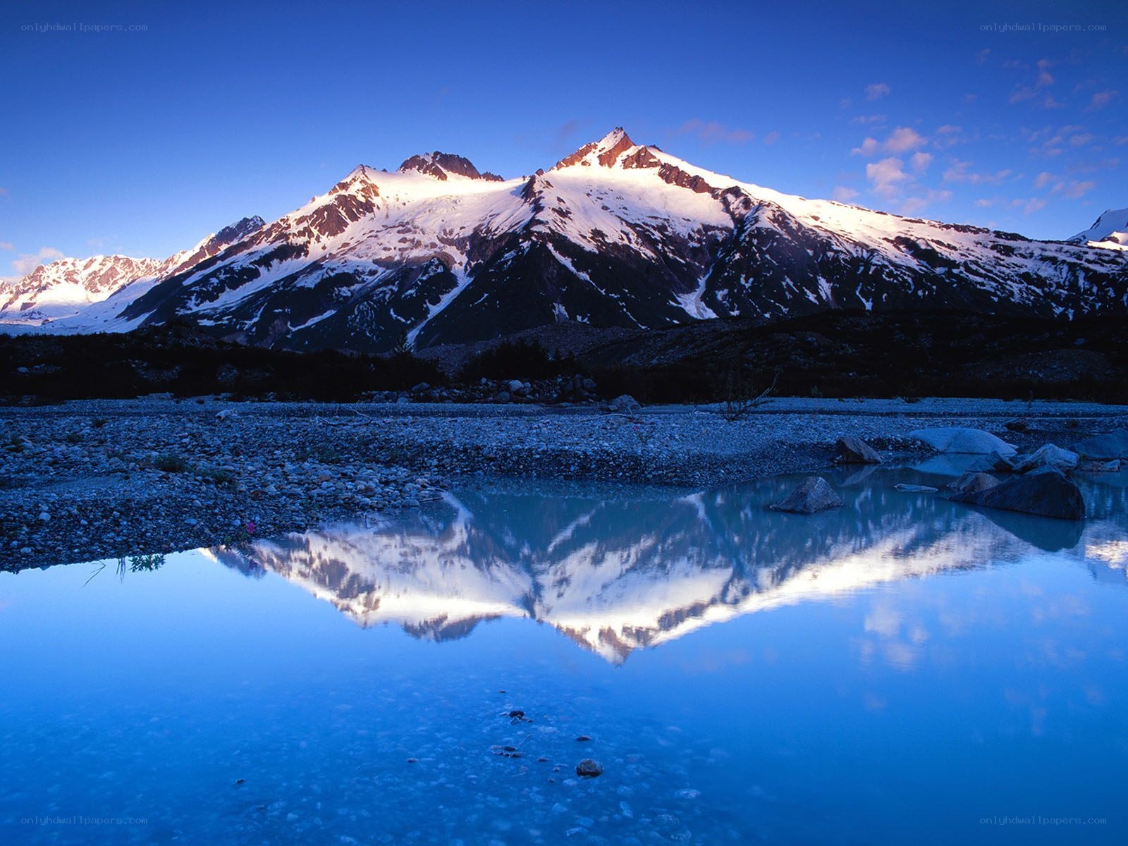 Snow-capped mountains reflected in lake