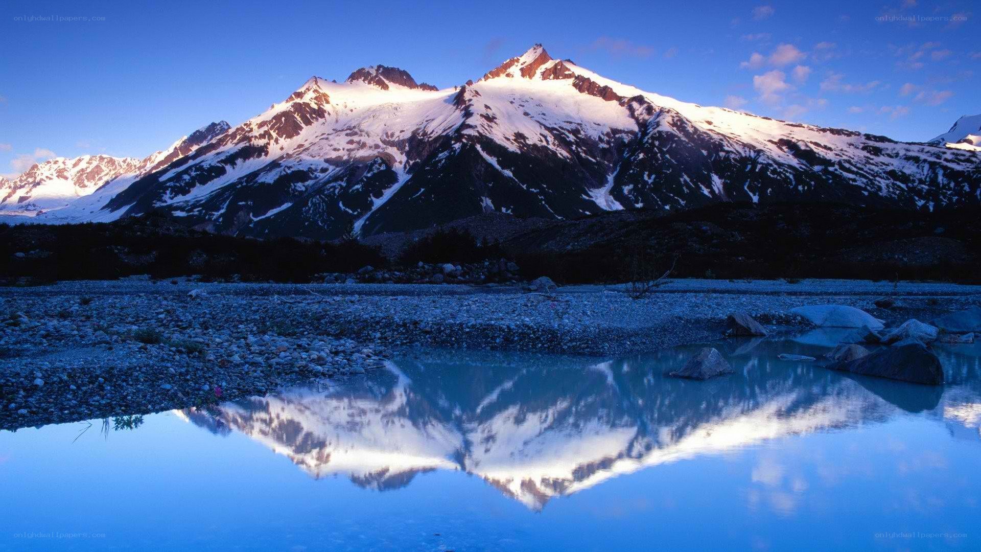 Snow-capped mountains reflected in lake