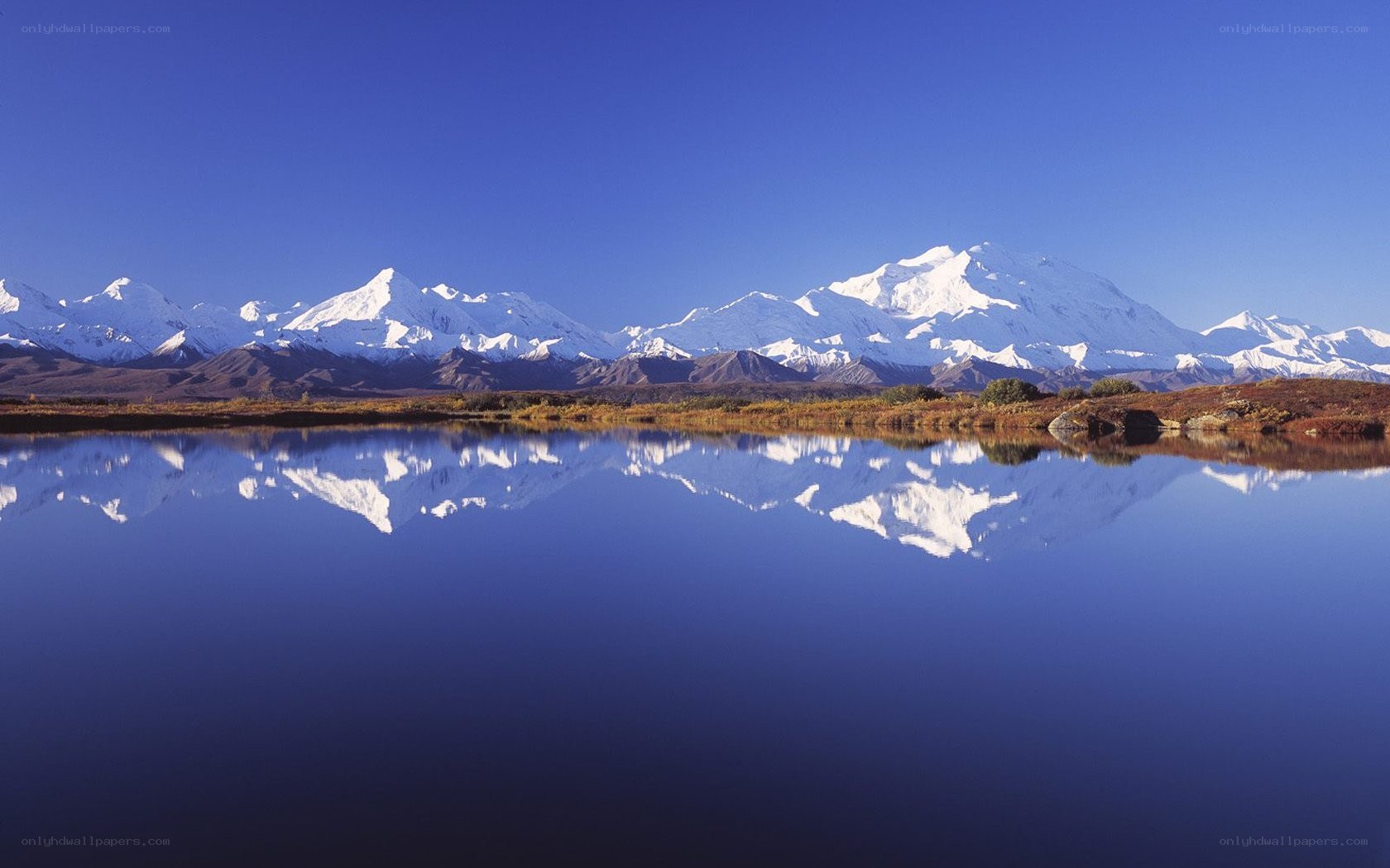 snow-capped mountains reflected in lake