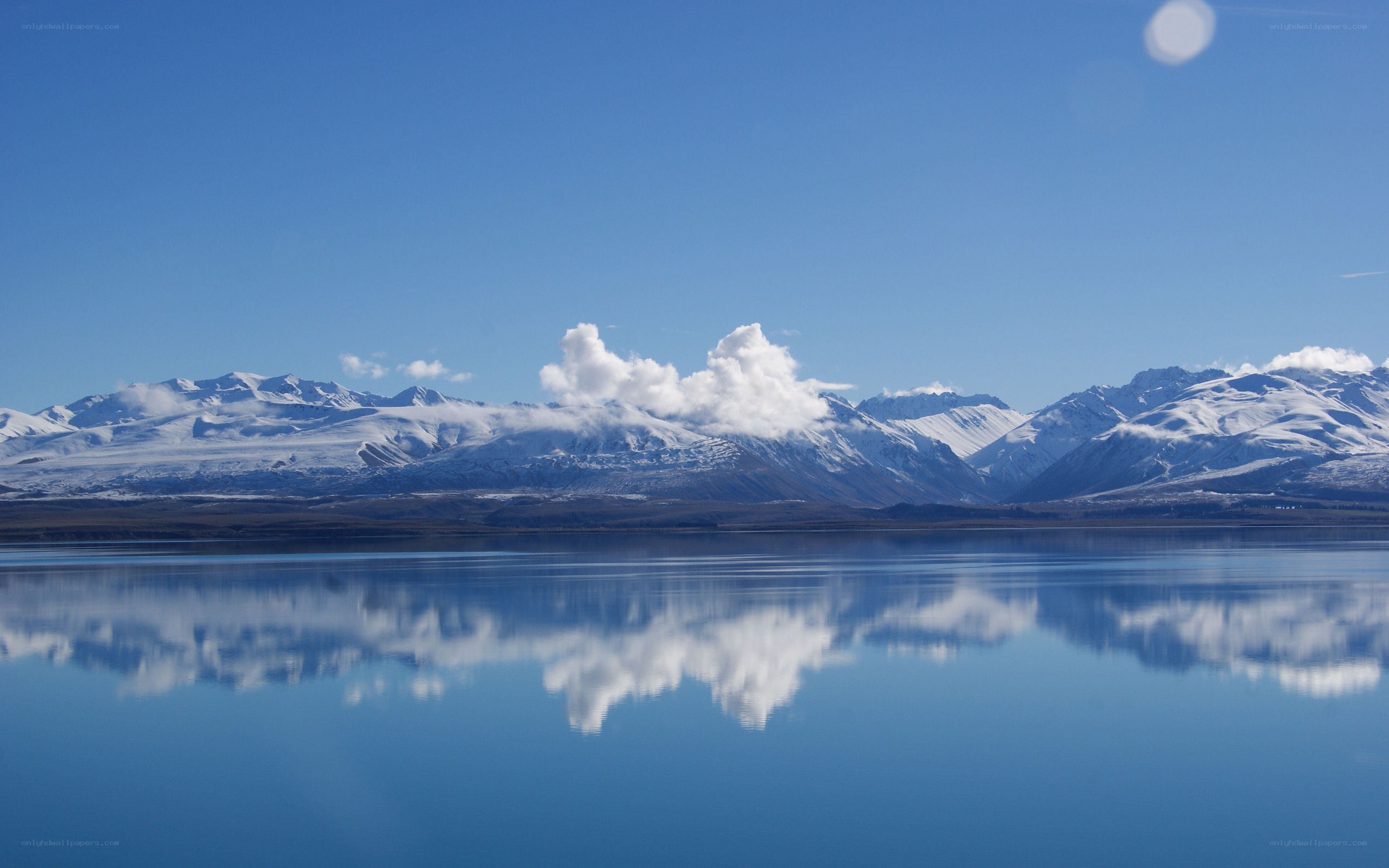 Snow-capped mountains reflected in lake
