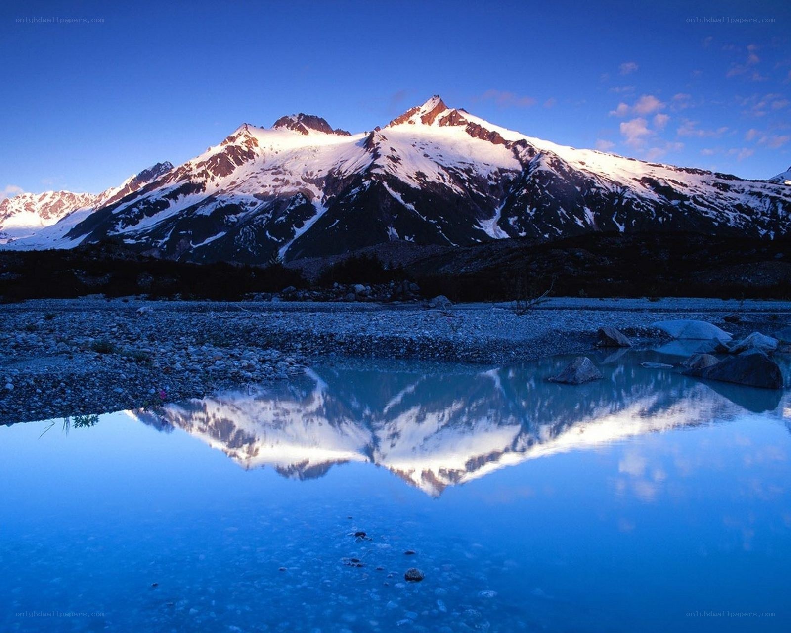 Snow-capped mountains reflected in lake