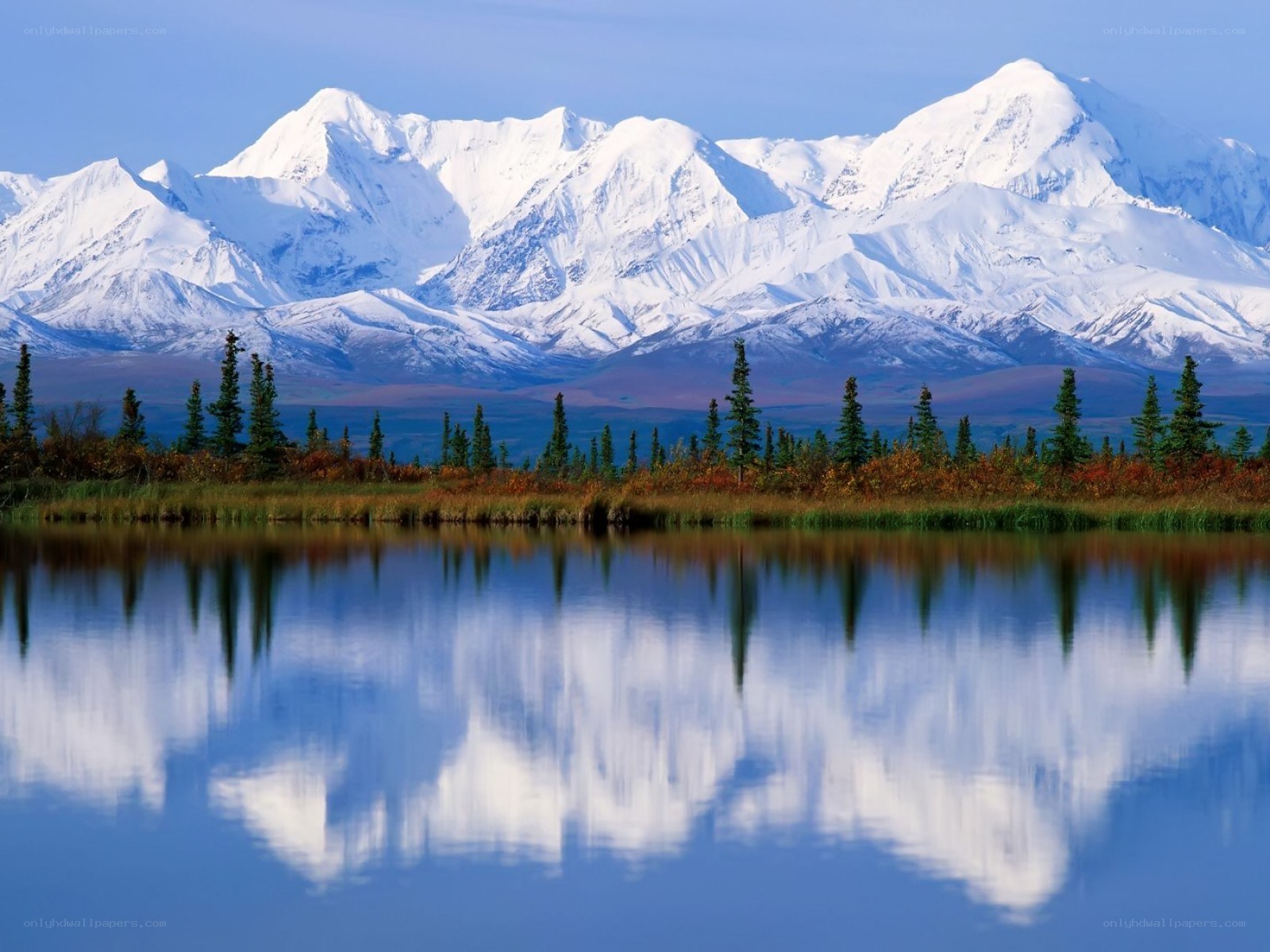 Snow-capped mountains reflected in lake