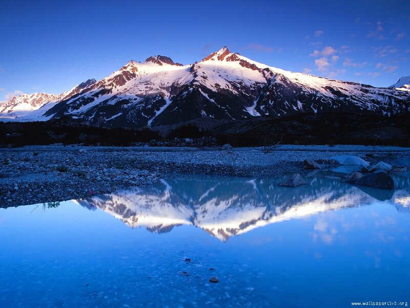 Snow-capped mountains reflected in lake