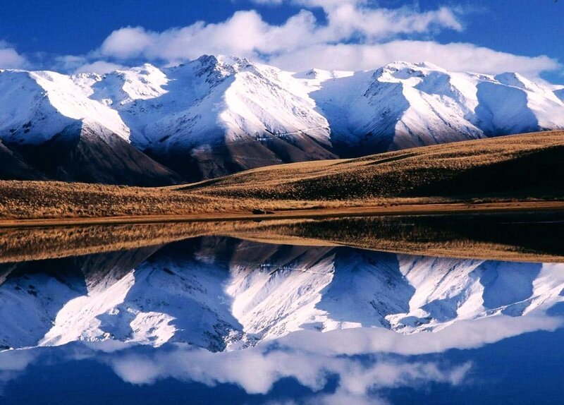 Snow-capped mountains reflected in lake