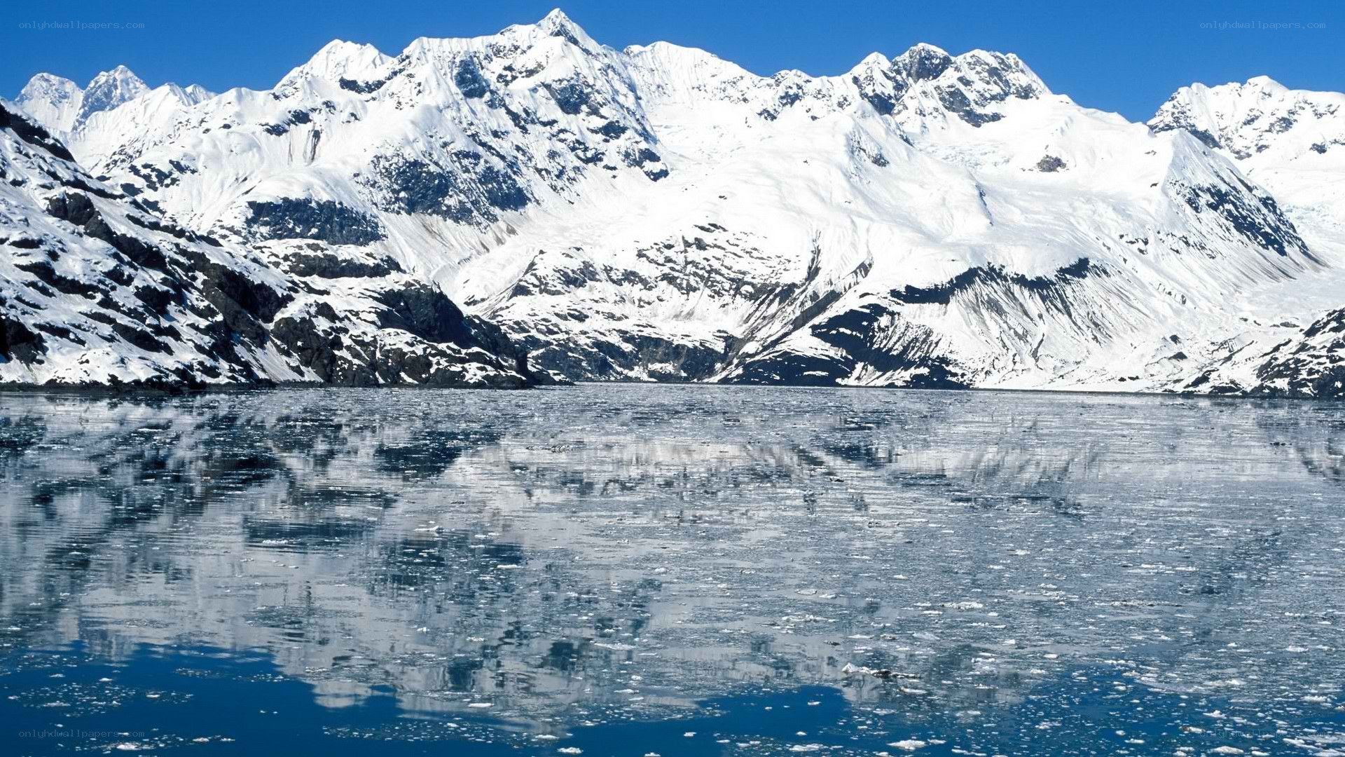 snow-capped mountains reflected in water