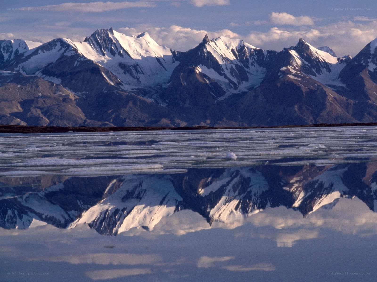 Snow-capped mountains reflected in water