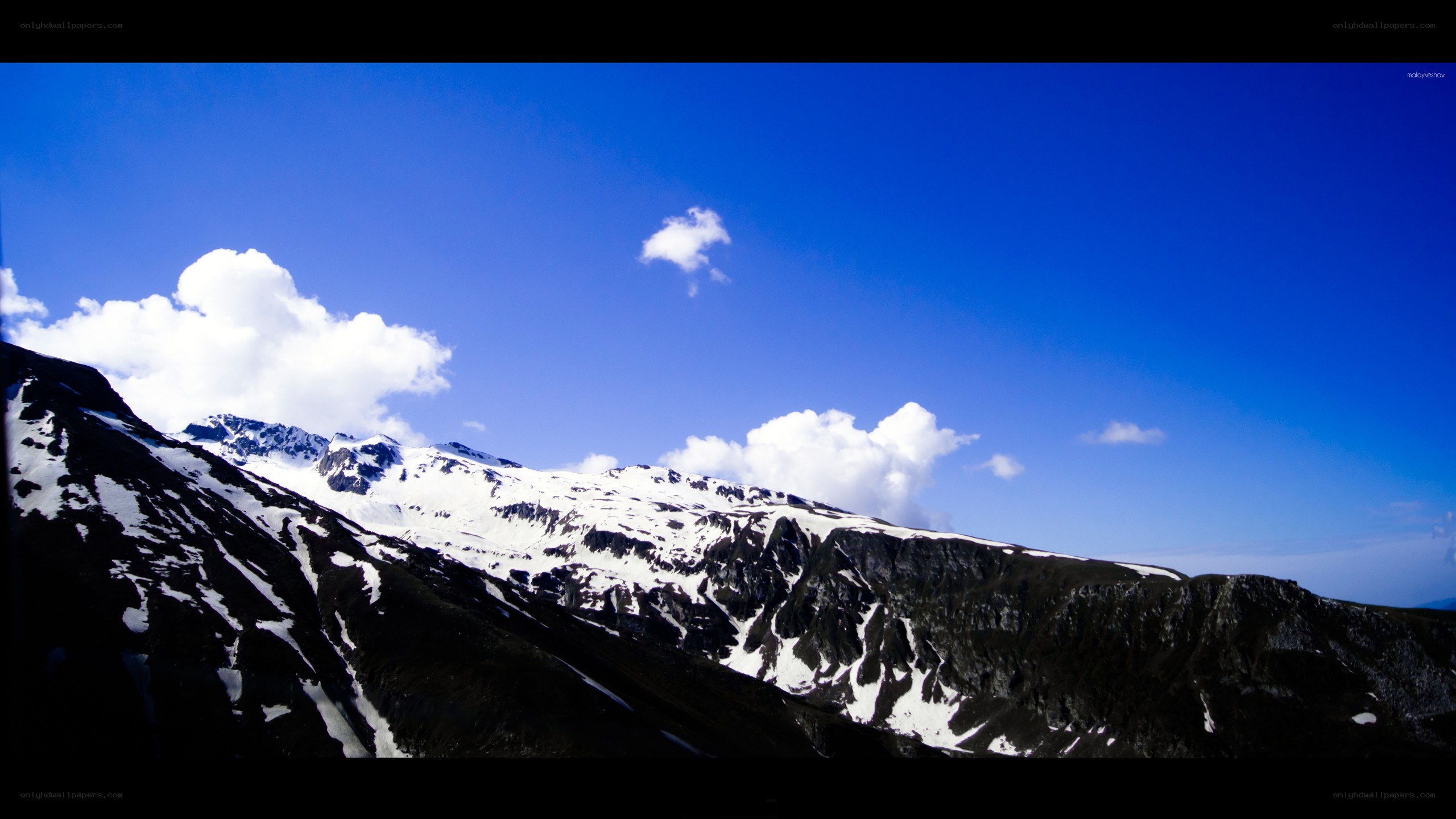 Snow-capped mountains under blue sky