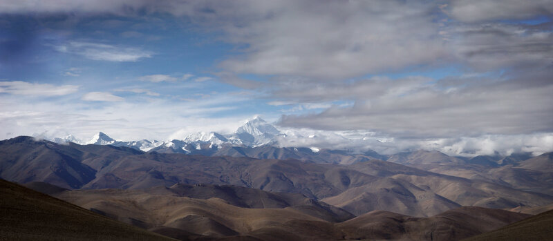 Snow-capped mountains under cloudy sky