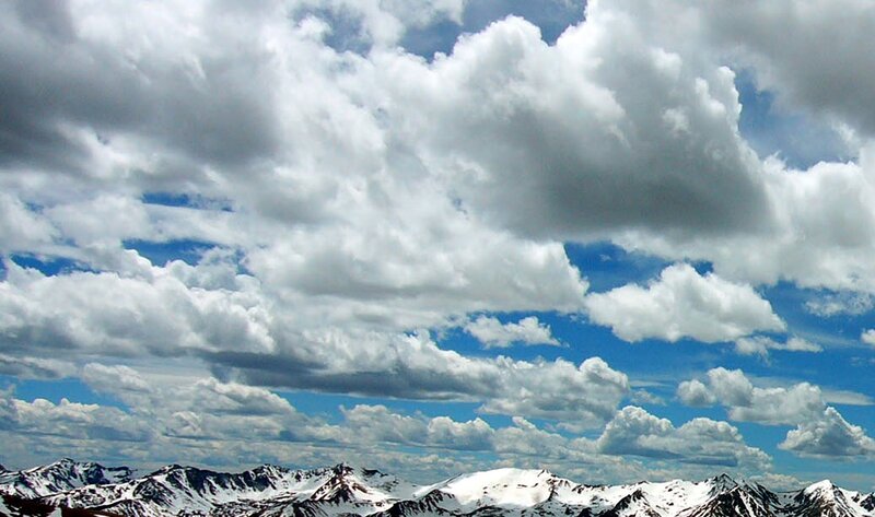 Snow-capped mountains under cloudy sky