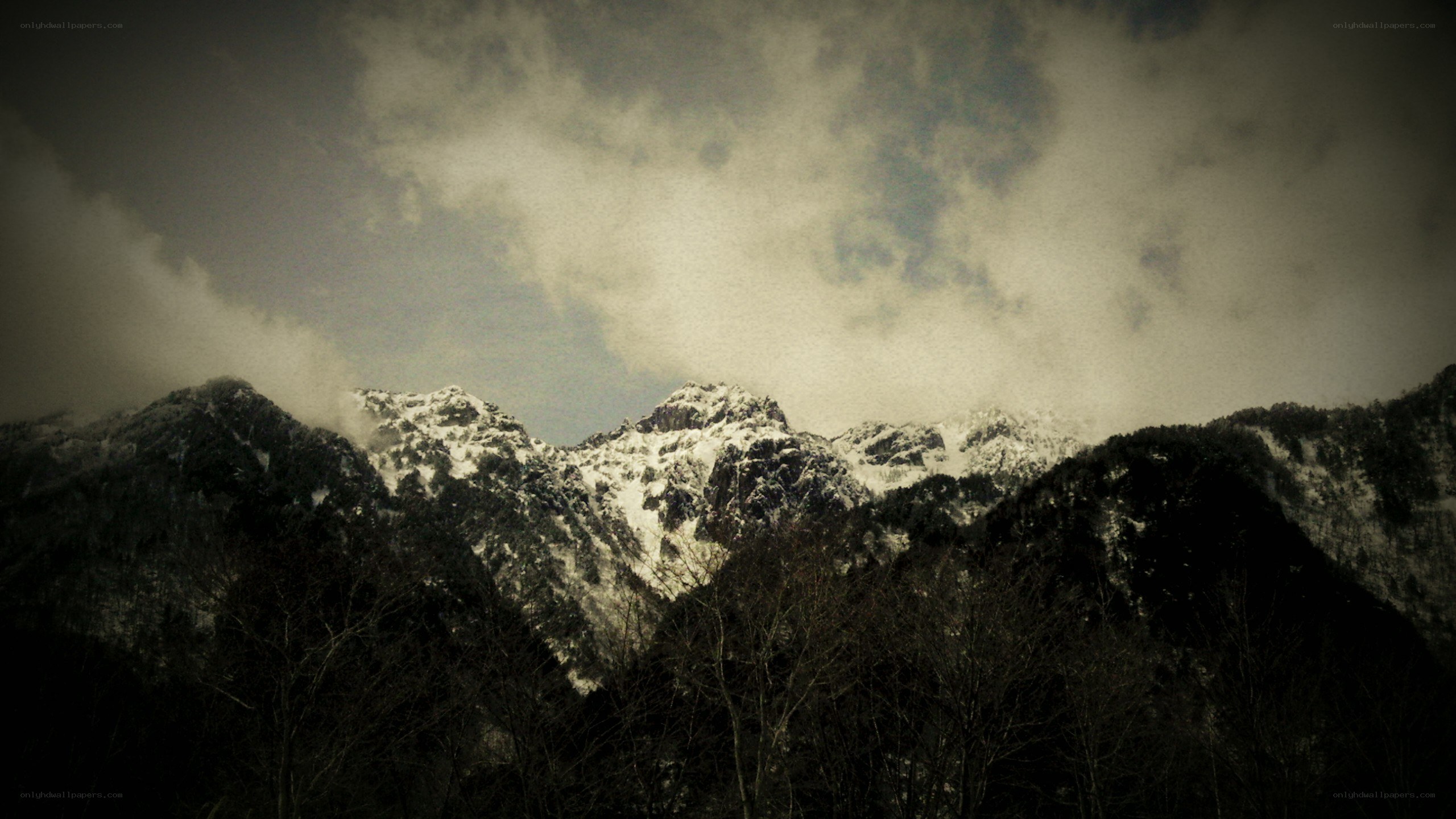 snow-capped mountains under cloudy sky