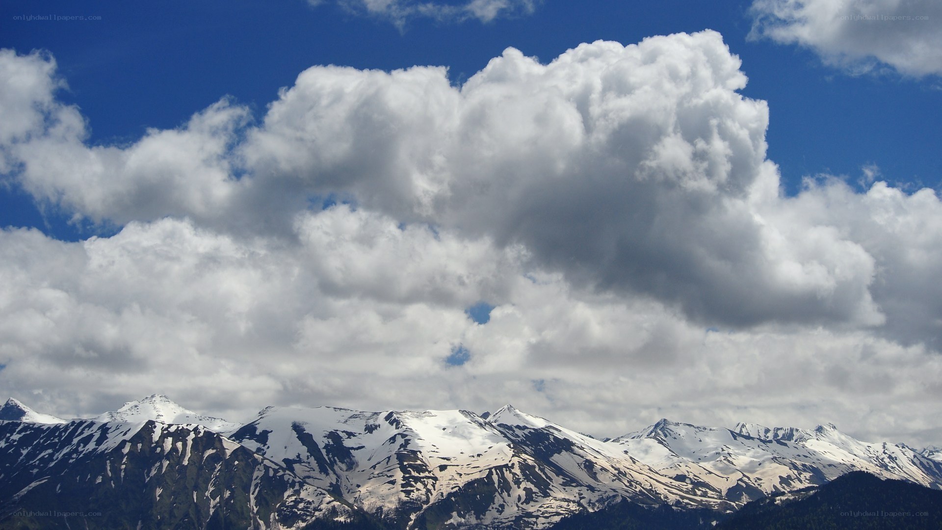 snow-capped mountains under cloudy sky