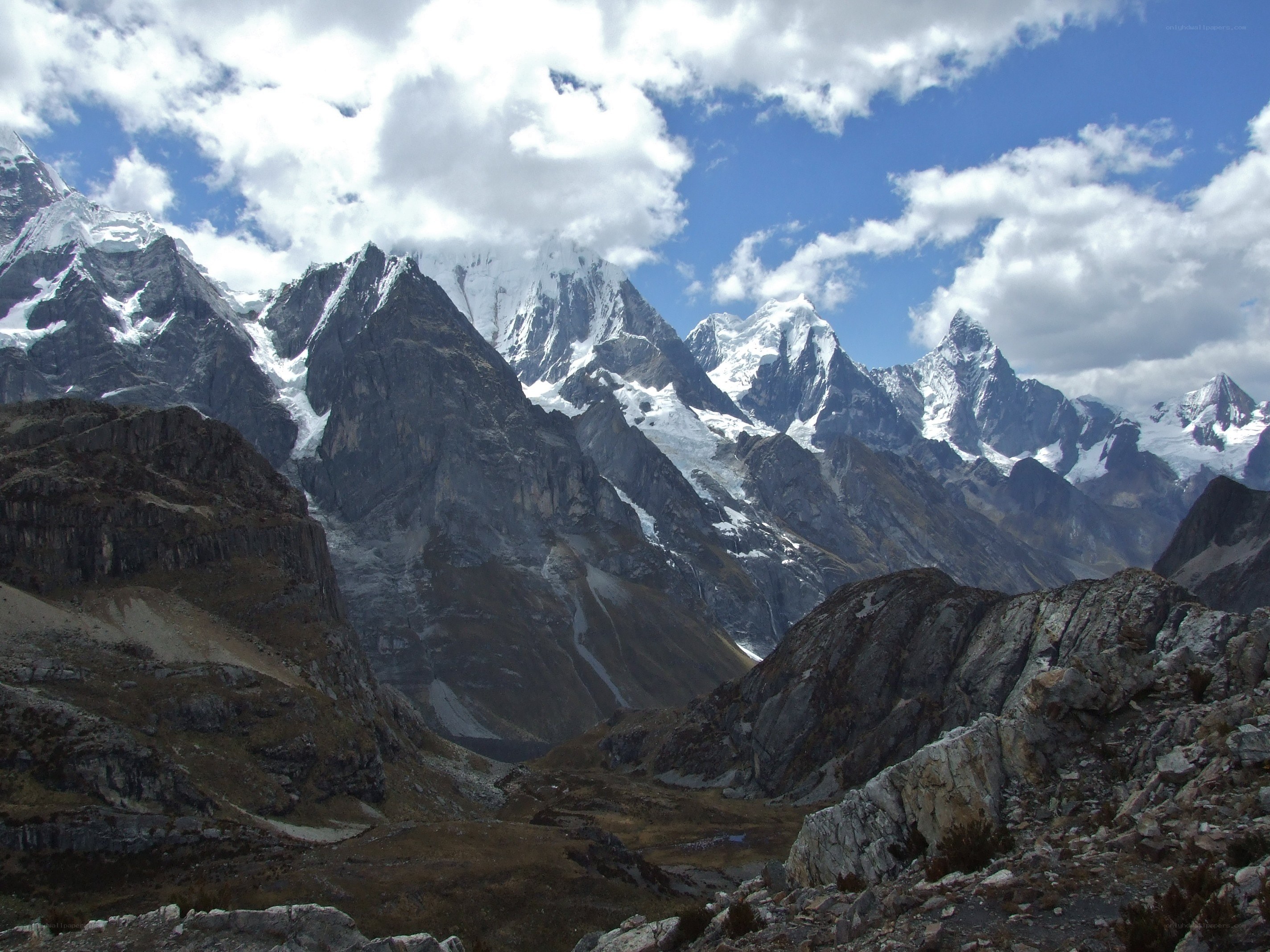 snow-capped mountains under cloudy sky