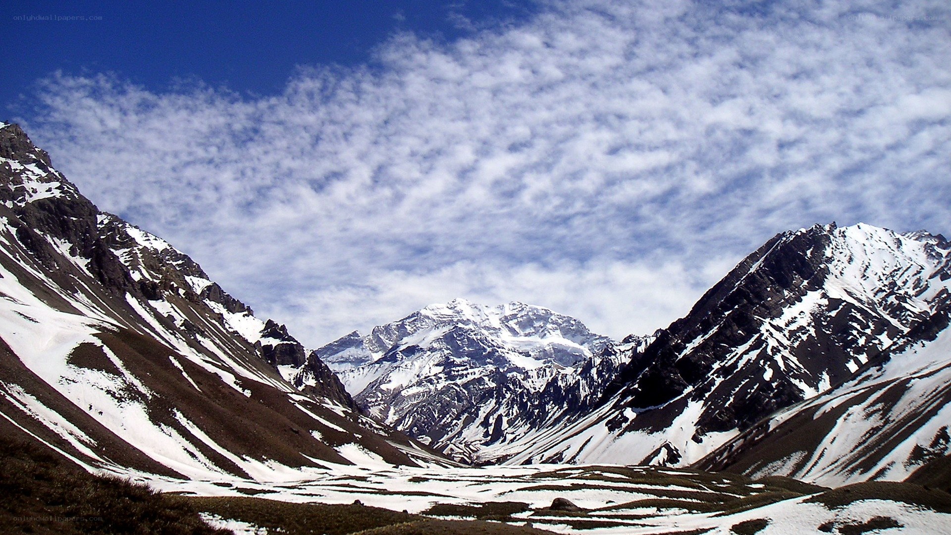snow-capped mountains under cloudy sky