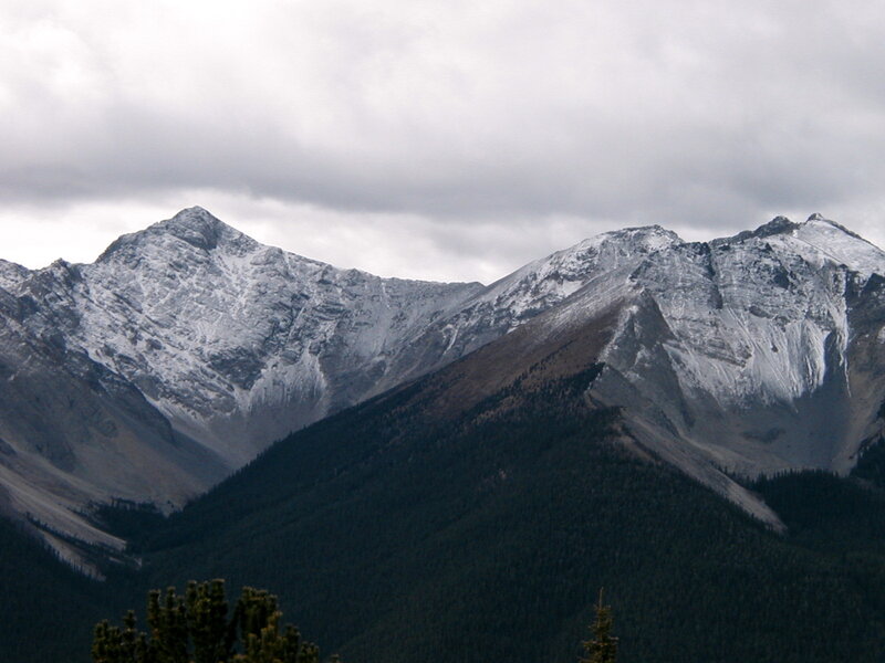 snow-capped mountains under cloudy sky