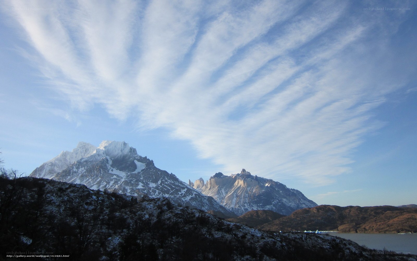 Snow-capped mountains under cloudy sky