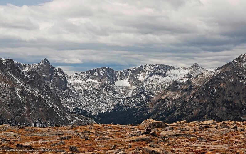 Snow-capped mountains under cloudy sky