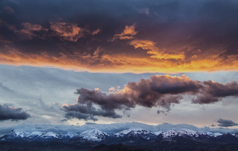 Snow-capped mountains under dramatic sky