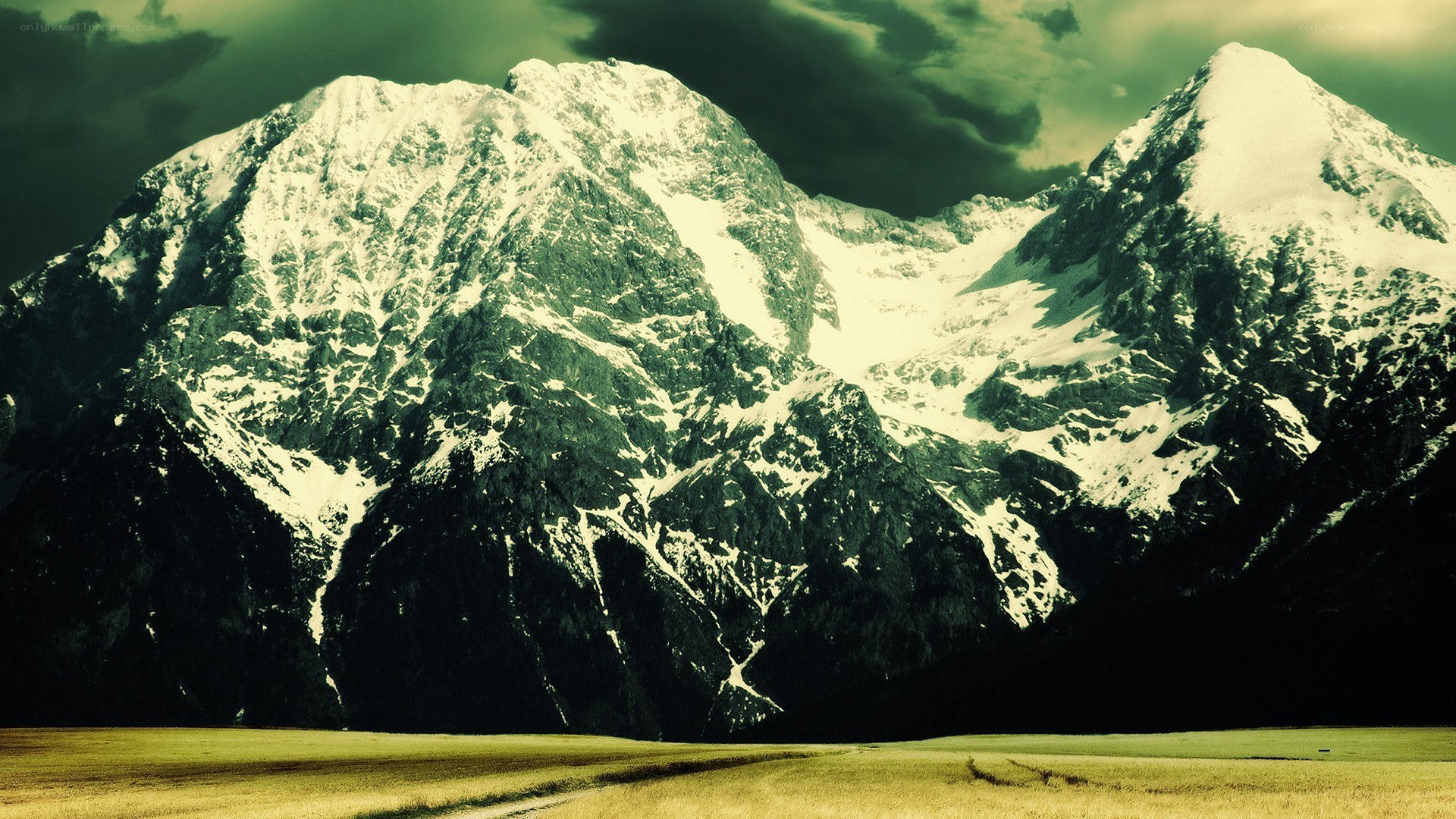 snow-capped mountains under stormy sky